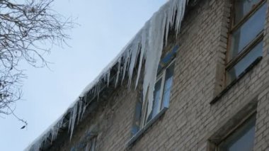 Eski terk edilmiş ev ve kış aylarında büyük miktarda erime buz sarkıtları ile balkon.