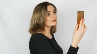 Bir akıllı telefonda konuşan ve beyaz bir arka plana karşı kendini hayran siyah bir elbise güzel bir genç seksi zarif kadın portre