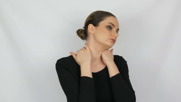 Retrato de bela jovem cansada que amassa o pescoço gira a cabeça sobre um fundo branco no estúdio — Vídeo de Stock