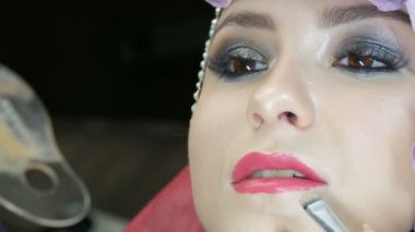 Profesyonel fırça ile blendable vurgu modeli yakın yukarı yüzüne uygulanır. Stüdyoda güzel kahverengi gözleri ile genç kız modeli. Profesyonel makyaj yüksek moda makyaj sanatçısı
