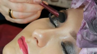 Profesyonel fırça ile blendable vurgu modeli yakın yukarı yüzüne uygulanır. Stüdyoda güzel kahverengi gözleri ile genç kız modeli. Profesyonel makyaj yüksek moda makyaj sanatçısı