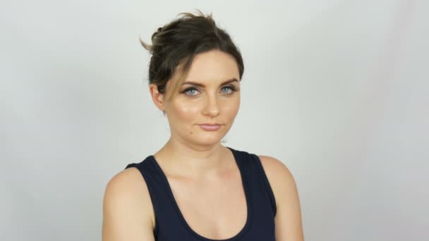 Portret van mooie jonge sexy vrouw in zwarte jurk goedkeuren met liefde zachtjes en glimlachend op zoek op een witte achtergrond in de Studio. — Stockvideo