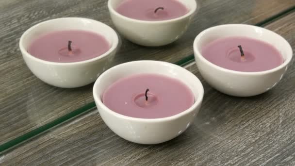 Hermosas velas púrpuras decorativas redondas y elegantes sobre la mesa en la habitación — Vídeo de stock