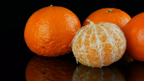 Meyve mandarin bir ayna yüzey üzerinde siyah bir zemin üzerine — Stok video