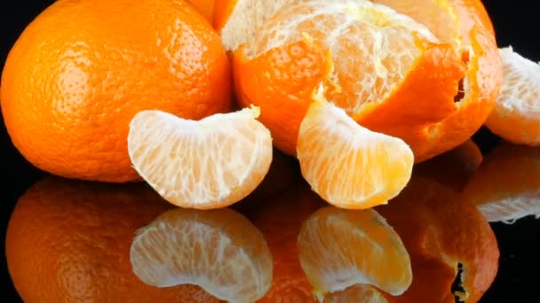 A fekete háttér, a tükör felület gyümölcsöket mandarin — Stock videók