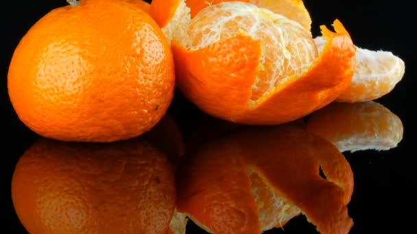 Frukt mandarin på svart bakgrund på en spegel yta — Stockvideo
