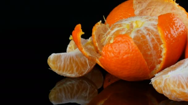 Frukt mandarin på svart bakgrund på en spegel yta — Stockvideo