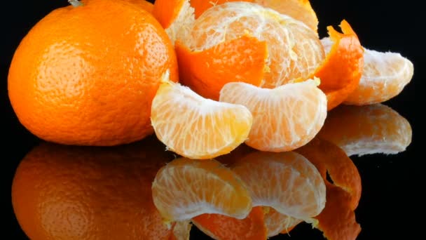 Fruits mandarin on a black background on a mirror surface — Stock Video