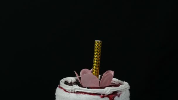 Candela su una bella torta bianca fresca dolce elegante con marmellata di ciliegie decorata con crema e fiocchi di cocco in cima. Torta di compleanno su sfondo nero . — Video Stock