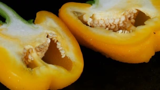 Fresh sweet yellow pepper paprika on black background and mirror surface — Stock Video