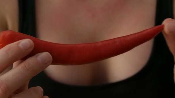 Γυναικεία χέρια αγγίζουν κόκκινες πιπεριές τσίλι σε μαύρο φόντο — Αρχείο Βίντεο