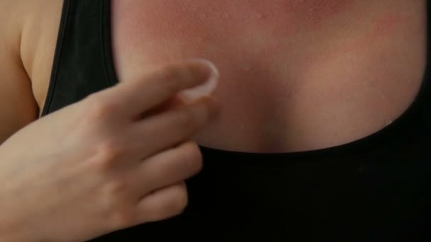 Les mains des femmes frottent sexuellement des glaçons sur la peau de sa poitrine en T-shirt noir sur un fond noir. Des gouttes d'eau coulent pour le décolleté des femmes — Video