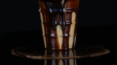 Siyah arka planda çikolata şurubu sosu DÖAN dondurma erime