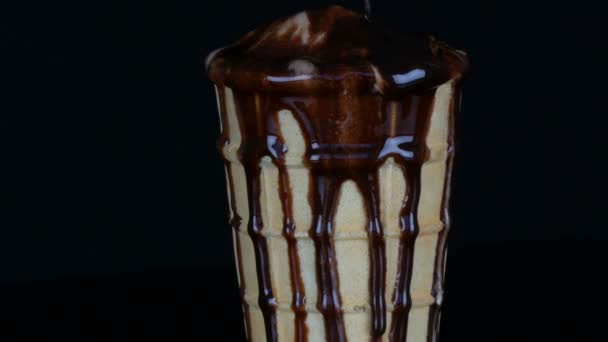 Παγωτό που λιώνει το σιρόπι σοκολάτας σε μαύρο φόντο — Αρχείο Βίντεο