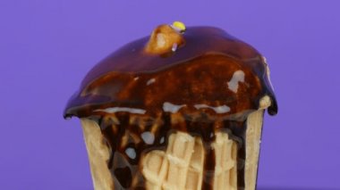 Açık mor arka planda uyku mavi renkli Sprinkles ile üst dekore vanilya dondurma döndürmek.