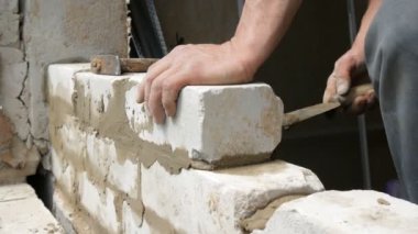 Erkek inşaatçı çimento ve ayakta duvara beyaz tuğla döşeme. Bina tuğlaları döşenen adamın elleri yakından görünümü