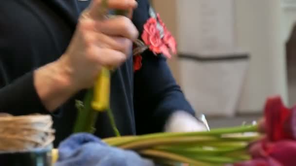 Manos de florista mujer haciendo un arreglo floral o un ramo de flores frescas — Vídeo de stock
