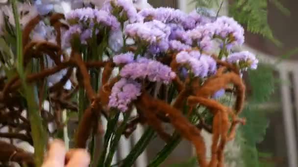 Mani di donna fiorista fare una composizione floreale o un mazzo di fiori freschi — Video Stock