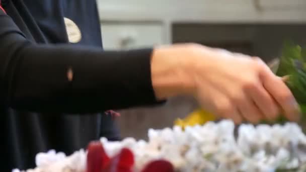 Lisse, Netherlands - April 22, 2019: A female florist demonstrates the process of making bouquet of fresh flowers in the royal park Keukenhof — Stock Video