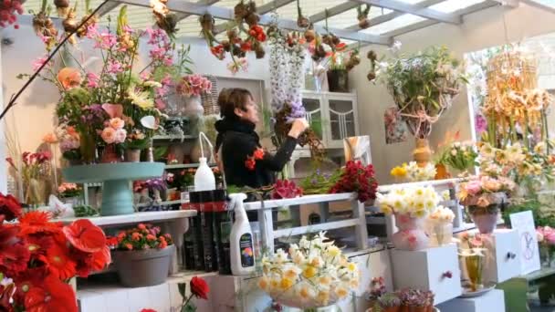 Lisse, Holanda - 22 de abril de 2019: Uma florista feminina demonstra o processo de fazer buquê de flores frescas no parque real Keukenhof — Vídeo de Stock