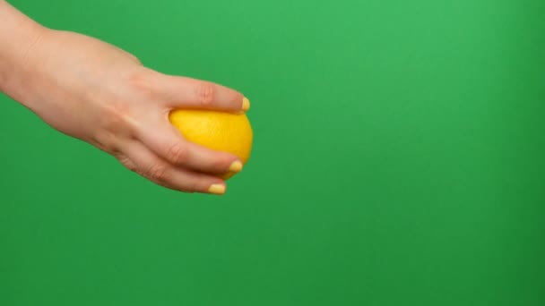 女性手与黄色修甲挤出半个柠檬的绿色色度关键背景 — 图库视频影像