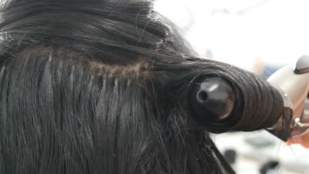 Μακριά όμορφα μαύρα μαλλιά στυλίστας μπούκλες. Χτένισμα και κέρλινγκ. Κάψουλες επέκτασης μαλλιών στο κεφάλι — Αρχείο Βίντεο