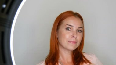 Güzel kızıl saçlı yetişkin orta yaşlı kadın model stüdyoda kamera önünde poz