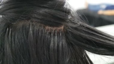 Uzun güzel siyah saç curler stilist bukleler. Saç şekillendirme ve kıvırma. Kafada Saç Uzatma Kapsülleri