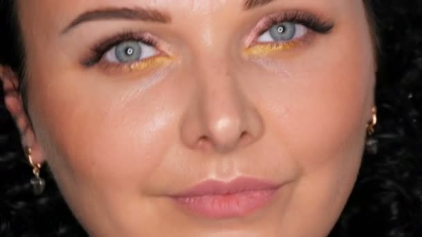 Mooie jonge brunette Kaukasische vrouw met krullend zwart haar poseren en glimlachend in de voorkant van de camera close-up — Stockvideo