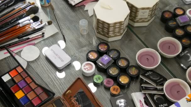 Kamjanskoe, Ukrajina-16. březen 2019: profesionální kosmetika na stole v ateliéru. Vícebarevné rtěnky, stíny, základ v make-up módním průmyslu — Stock video