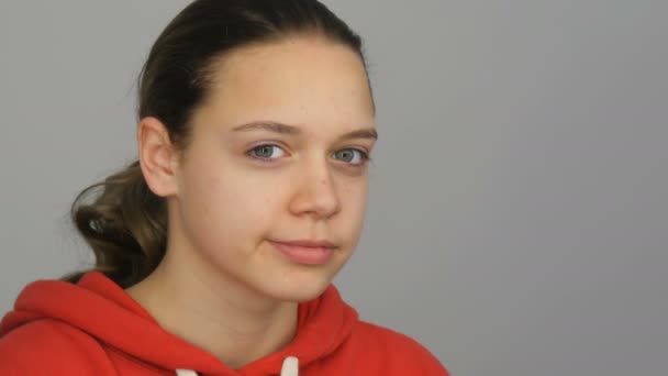 Teen girl in red sweater looks into the camera in the studio — Stock Video