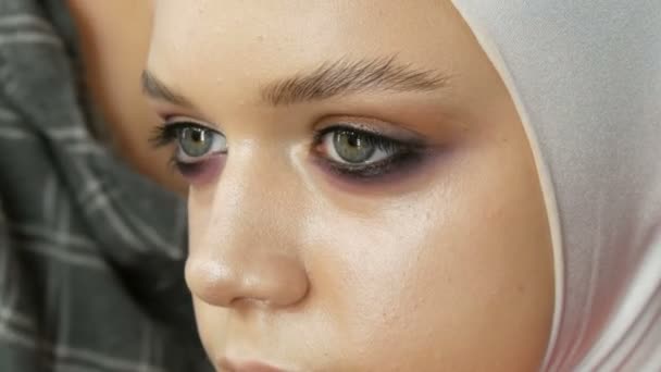 Haute couture. Modèle de fille professionnelle posant sur la caméra en image blanche, et maquillage yeux fumés dans le studio — Video