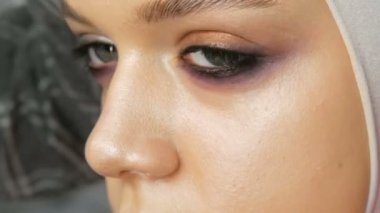 Kadın makyaj sanatçısı stilist genç modelin özel makyaj fırçası ile makyaj moda pembe dumanlı gözler yapar