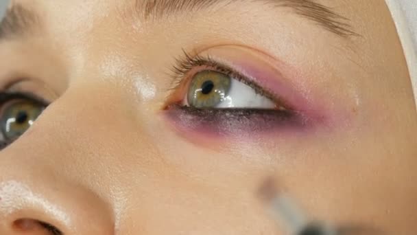 Mujer maquillaje artista estilista hace que el maquillaje de moda rosa ojos ahumados con cepillo de maquillaje especial de modelo joven — Vídeos de Stock