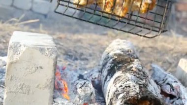 Doğada barbekü ızgara et ızgara. Kızartma Taze Et, Tavuk Barbekü, Sosis, Kebap, Hamburger, tatil. Adam ızgarayı çeviriyor.