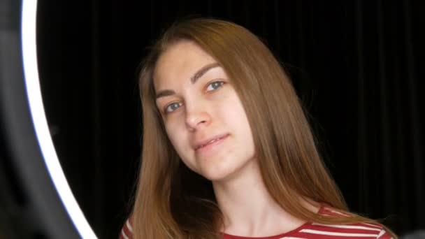 Porträtt av en ganska ung tjej modell med akne problematisk hud och långa blonda hår på svart bakgrund i studion — Stockvideo