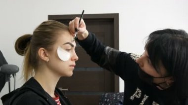 3 Nisan 2019 - Kamenskoe, Ukrayna: Profesyonel makyaj sanatçısı yapar güzel bir model kahverengi tonuna makyaj dumanlı gözler yeşil gözlü