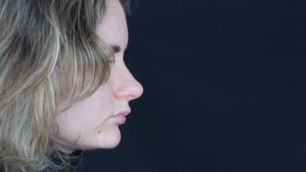 Crying psychedelic depressive crazy young woman with flawed make-up rotating on black background — Stock Video