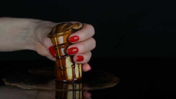 Mão feminina com uma manicure vermelha espreme sexualmente xícara de waffle com sorvete derretendo — Vídeo de Stock