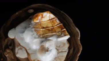Siyah arka planda çikolata şurubu sosu DÖAN dondurma erime