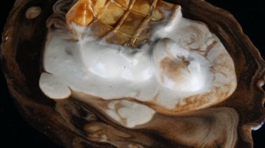 Siyah bir arka plan üzerinde waffle fincan eritilmiş beyaz dondurma