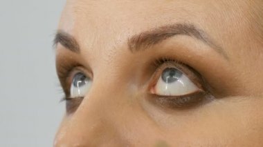 Profesyonel usta makyaj sanatçısı güzellik salonu yakından görünümünde model göz üzerinde özel fırça ile bej göz farı uygular