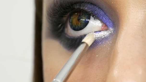 Junge schöne sexy Mädchen Models machen blauen Abend Make-up rauchige Augen und mit falschen Wimpern. Augen mit mehrfarbigen Kontaktlinsen Nahsicht — Stockvideo