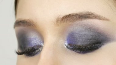 Genç güzel seksi kız modelleri mavi akşam dumanlı gözleri makyaj ve yanlış kirpikile yapmak. Çok renkli kontakt lensleri olan gözler