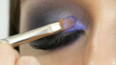 Genç güzel seksi kız modelleri mavi akşam dumanlı gözleri makyaj ve yanlış kirpikile yapmak. Çok renkli kontakt lenslere sahip gözler yakından görünümü