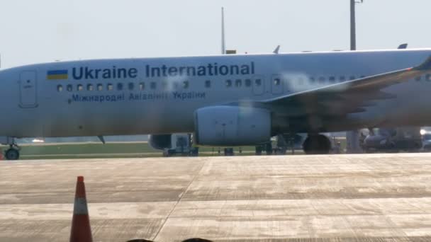 Borispol, Ucraina - 21 aprile 2019: L'aereo in aeroporto viene scaricato dopo il volo. Aereo sulla pista per prepararsi alla partenza. Un aereo di passaggio, vista dal terminal dell'aeroporto — Video Stock