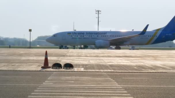 Borispol, Ucraina - 21 aprile 2019: L'aereo in aeroporto viene scaricato dopo il volo. Aereo sulla pista per prepararsi alla partenza. Un aereo di passaggio, vista dal terminal dell'aeroporto — Video Stock