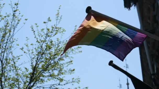 Gay Pride Rainbow Flag hbt flyger. En flerfärgad regnbåge flagga, en symbol för okonventionell trafik, gungar i vinden i huvudstaden i Nederländerna, Amsterdam — Stockvideo