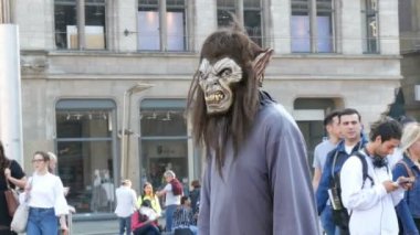 Amsterdam, Hollanda - 21 Nisan 2019: Korkunç canavar kostümü içinde Barajın ana meydanında bir animatör onunla fotoğraf çekmek için turistler tarafından geçen davet