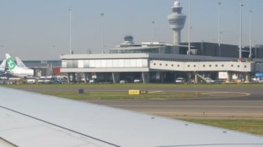 Amsterdam, Hollanda - 21 Nisan 2019: Uçak dünyanın en büyük havaalanlarından biri olan Schiphol'a iniyor. Diğer birçok uçak terminallerin yakınında yer almaktadır
